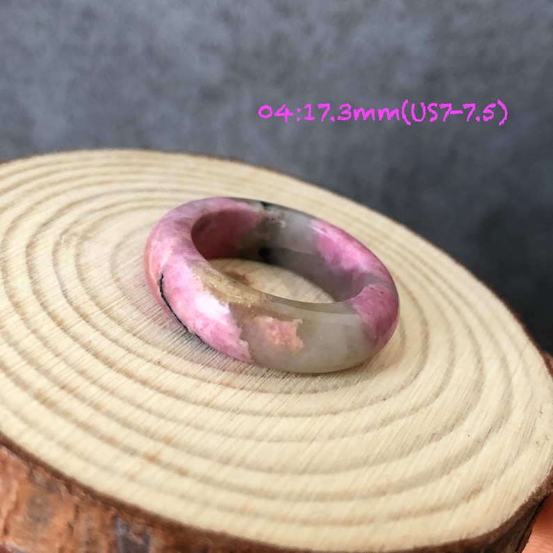 Pode incluir: Um anel rosa e branco feito de rodocrosita, um tipo de pedra preciosa. O anel tem um tamanho de 17,3 mm, o que corresponde a um tamanho americano 7-7,5.