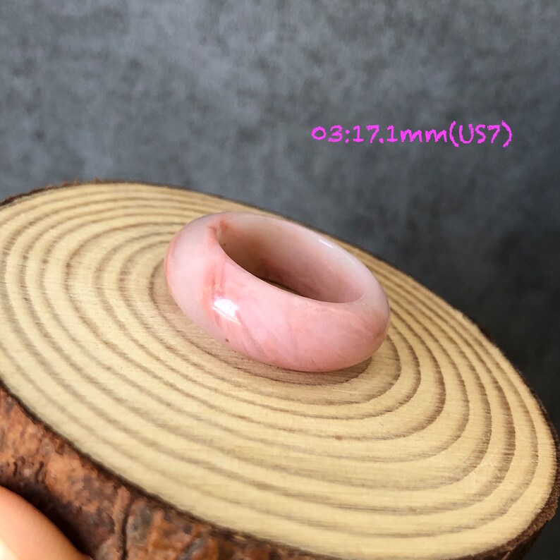 Pode incluir: Um anel de pedra preciosa rosa com um acabamento liso e polido. O anel tem 17,1 mm de tamanho e est&aacute; etiquetado como tamanho 7 US.