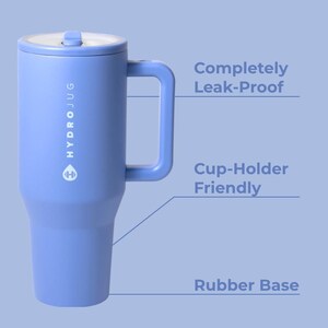 Puede incluir: Una Hydrojug azul b&iacute;garo con asa y tapa. La jarra tiene el nombre de la marca impreso verticalmente en el lateral. El texto de la imagen dice "Completely Leak-Proof", "Cup-Holder Friendly" y "Rubber Base".