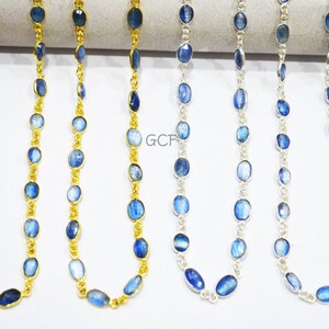 May include: Four strands of blue gemstone beads on a gold and silver chain. The beads are oval shaped and have a light blue color with a shimmery effect. The chains are delicate and have a polished finish.