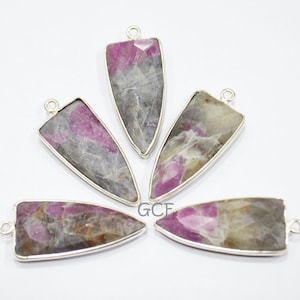 May include: Five silver arrow-shaped pendants with pink and gray gemstone inserts.
