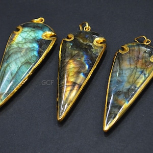 Può includere: Tre ciondoli a forma di punta di freccia in labradorite iridescente con bordo dorato. I ciondoli misurano circa 5 cm di lunghezza e hanno una punta appuntita.