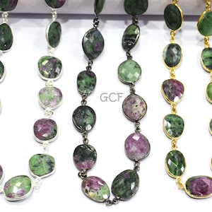 May include: Three strands of gemstone beads, each with a different metal chain. The beads are a mix of green and pink, and the chains are silver, black, and gold.