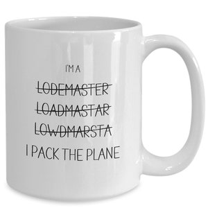 May include: White ceramic coffee mug with black text that reads "I'm a Lodemaster Loadmaster Lowdmarsta I pack the plane".