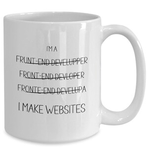 May include: White ceramic coffee mug with black text that reads "I'MA FRUNT-END DEVELUPPER FRONT-END DEVLOPER FRONTE-END DEVELUPA I MAKE WEBSITES"