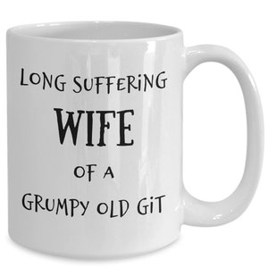 May include: White ceramic coffee mug with black text that reads "Long Suffering Wife of a Grumpy Old Git."