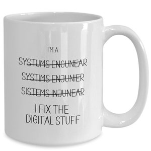 May include: White ceramic coffee mug with black text that reads "I'm a Systems Engineer I fix the digital stuff".