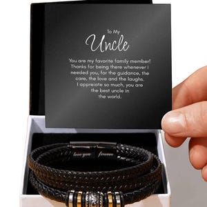 Könnte beinhalten: Ein schwarzes Lederarmband-Set mit goldenen und silbernen Akzenten in einer weißen Box mit einer Karte, auf der steht: "An meinen Onkel Du bist mein Lieblingsfamilienmitglied! Danke, dass du immer da bist, wenn ich dich brauche, für deine Führung, deine Fürsorge, deine Liebe und dein Lachen. Ich schätze es sehr, du bist der beste Onkel der Welt. Ich liebe dich für immer"