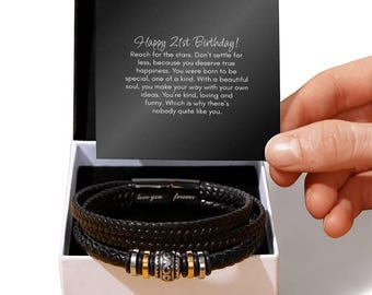 May include: A black leather bracelet with a silver clasp and gold accents. The bracelet is in a white box with a black lid. The lid has a message that reads "Happy 21st Birthday! Reach for the stars. Don't settle for less, because you deserve true happiness. You were born to be special, one of a kind. With a beautiful soul, you make your way with your own ideas. You're kind, loving and funny. Which is why there's nobody quite like you."