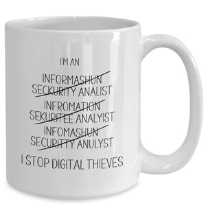 May include: White ceramic coffee mug with black text that reads "I'm an" with several misspelled words crossed out, including "Informashun", "Seckurity Analyst", "Infromation", "Sekuritee Analyst", "Infomashun", and "Security Anulyst". The text continues with "I Stop Digital Thieves".