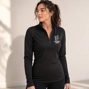 May include: Black long-sleeve athletic top with a quarter-zip closure. The top features a white logo with the text "CUSTOM LOGO" on the upper chest. The top is made of a textured fabric.