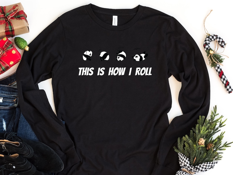 May include: Black long-sleeve shirt with a graphic of five panda bears rolling down a hill. The text "This is how I roll" is printed below the panda bears.