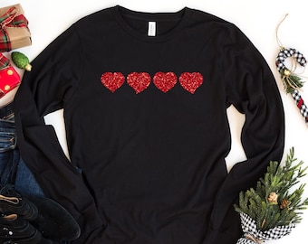May include: Black long-sleeved shirt with four red glitter hearts on the front.