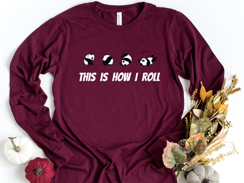 May include: A maroon long-sleeved t-shirt with a graphic of five pandas rolling. The text "This is how I roll" is printed below the pandas.