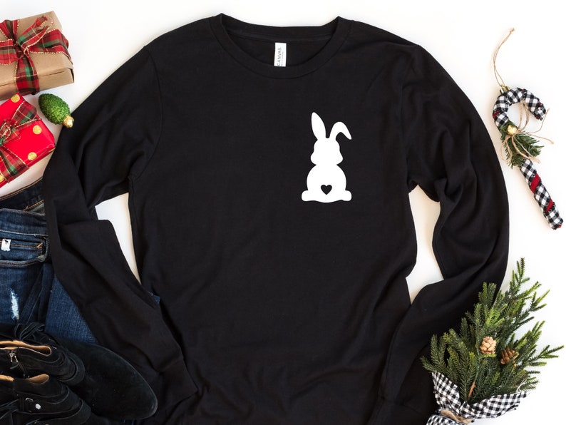 May include: Black long-sleeved shirt with a white silhouette of a bunny rabbit with a heart on its chest.