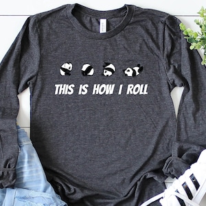 May include: A dark gray long-sleeved t-shirt with a white graphic of five pandas rolling, and the text "This is how I roll".