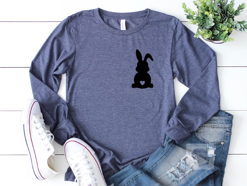 May include: A navy blue long-sleeved shirt with a black silhouette of a rabbit with a heart on its chest.