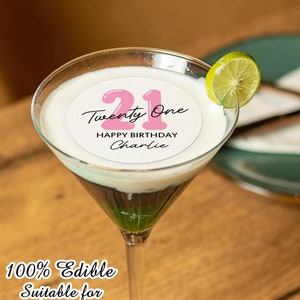 May include: A white round edible cake topper with pink 21 in a balloon font and the text "Twenty One" and "Happy Birthday Charlie".