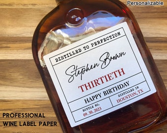 Può includere: Un'etichetta bianca con testo nero che recita "Distillato alla perfezione" e "Stephen Brown" in corsivo. L'etichetta include anche il testo "Thirtieth", "Buon compleanno", "Numero di bottiglia 09.30.2023", "Distillato a Houston, TX". L'etichetta è attaccata a una bottiglia di vetro marrone.