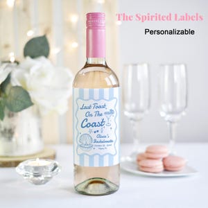 May include: A personalized wine bottle label with a blue and white striped background. The label features a seashell, a cocktail glass, and the text "Last Toast, On The Coast Olivia's Bachelorette October 18, 2023 Miami, FL".