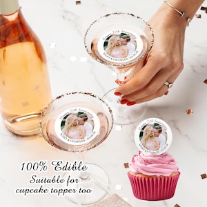 May include: Two clear glass martini glasses with edible cupcake toppers. The toppers are round and white with a photo of a couple and the text "Happy 25th Anniversary Mary & Charles 02.16.26". A pink cupcake with a topper is also shown.