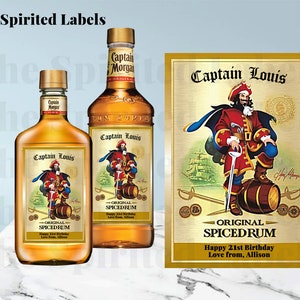 May include: Two bottles of Captain Morgan spiced rum with custom labels featuring a cartoon pirate with a red and gold costume, a sword, and a barrel. The labels say "Captain Louis - Original Spiced Rum" and "Happy 21st Birthday, Love from, Allison".