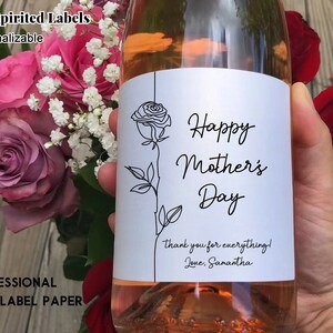 May include: A white wine bottle label with a black line drawing of a rose and the text "Happy Mother's Day" with a thank you message below.