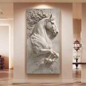 May include: A large, rectangular wall art piece featuring a detailed relief sculpture of a rearing horse. The sculpture is in shades of gray and white, with the horse's mane flowing dramatically. The artwork is mounted on a neutral-colored wall.