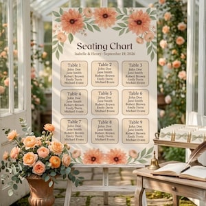 May include: A wedding seating chart on an easel, featuring a floral design with peach-colored flowers and green leaves. The chart lists names under table numbers. The text reads "Seating Chart, Isabelle & Henry - September 19, 2026."