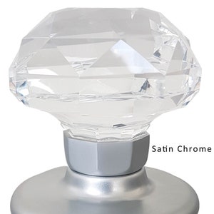 May include: A clear crystal door knob with a faceted design. The knob is mounted on a satin chrome base.