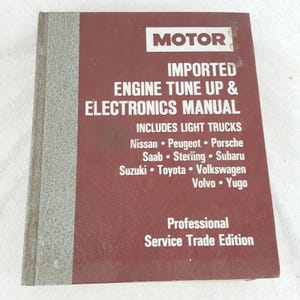 May include: A maroon and gray Motor Imported Engine Tune Up & Electronics Manual. The cover includes the text "Includes Light Trucks" and lists Nissan, Peugeot, Porsche, Saab, Sterling, Subaru, Suzuki, Toyota, Volkswagen, Volvo, and Yugo.