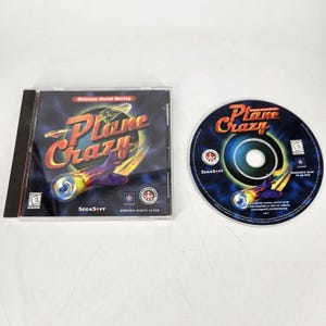May include: A Plane Crazy PC CD-ROM game in a clear plastic case, with the disc next to it. The cover art features a stylized airplane with flames and the title "Plane Crazy" in orange and yellow.