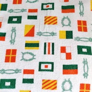 Peut inclure: Tissu blanc à motifs répétés de drapeaux de signalisation nautiques, de nœuds de corde et de motifs de corde verte. Les drapeaux présentent diverses couleurs et motifs, dont le rouge, le jaune, le vert et le blanc.