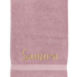 May include: A soft, pink towel with the name "Samira" embroidered in gold thread.