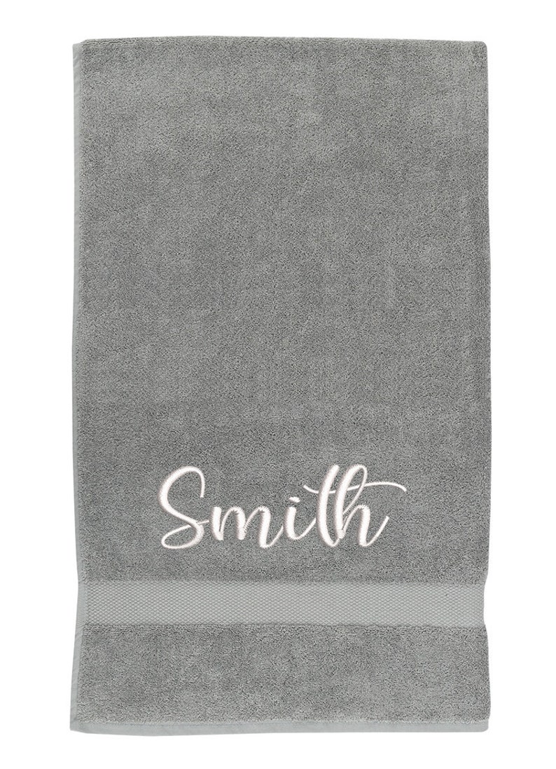 May include: Gray bath towel with the name "Smith" embroidered in white.