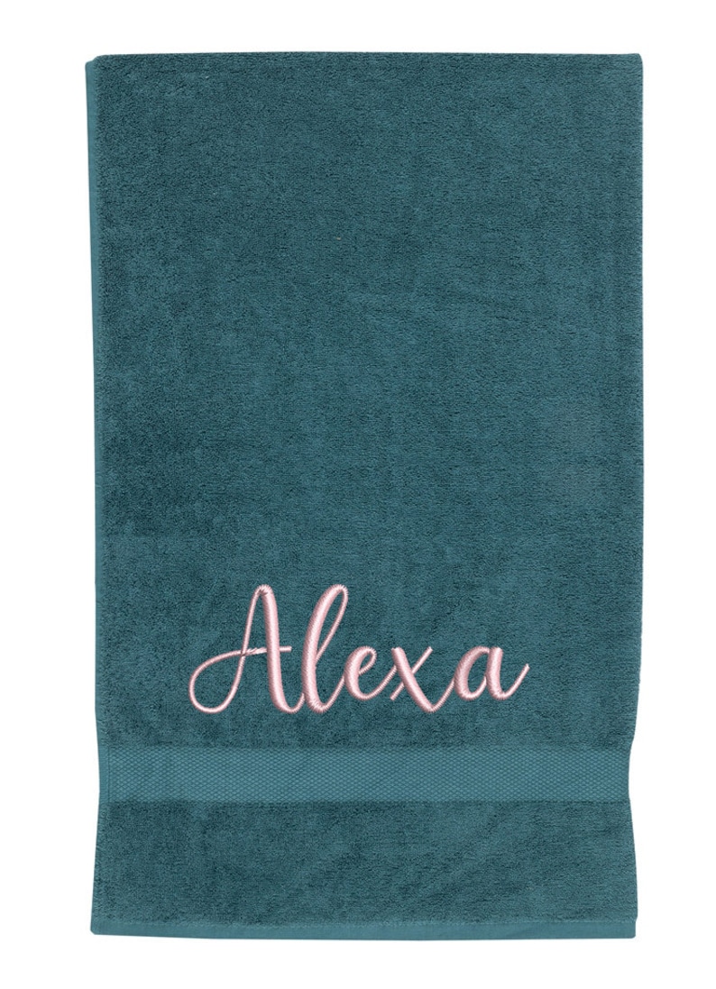 May include: A teal blue bath towel with the name "Alexa" embroidered in pink.