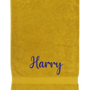 May include: A yellow bath towel with the name "Harry" embroidered in blue.