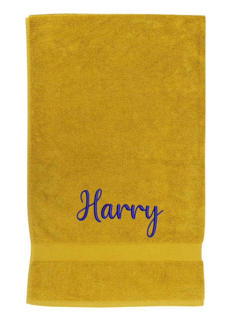 May include: A yellow bath towel with the name "Harry" embroidered in blue.