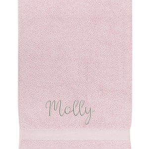 May include: A pink bath towel with the name "Molly" embroidered in white.