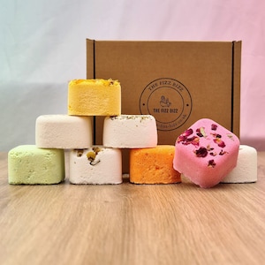 All 8 of our shower steamers artfully arranged in front of their presentation box. For information on their scents refer to scent page. For information on their size use the dimension page.