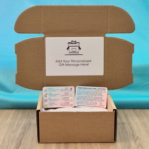 The open gift box showing the personalisation option and the included shower steamer scent and selection card against a blue background