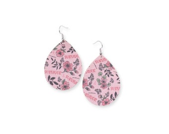 May include: A pair of pink teardrop earrings with a floral pattern and the word "SURVIVOR" printed on them. The earrings feature a pink ribbon, a symbol of breast cancer awareness.