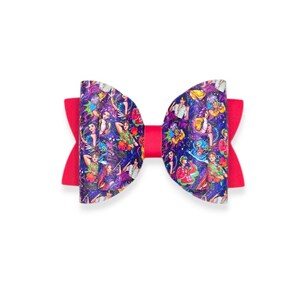 May include: A vibrant hair bow featuring a colorful design with a red center. The bow's ends are a solid red, while the main section showcases a detailed pattern with figures and floral elements, set against a dark background.