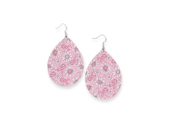 May include: Pink teardrop-shaped earrings with a white daisy and pink ribbon pattern.