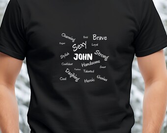 Op de afbeelding: Zwart T-shirt met witte tekst die "Charming, Sexy, John, Handsome, Dashing, Cool, Bold, Brave, Loyal, Strong, Stylish, Confident, Fearless, Talented, Heroic, Smart, Genius" zegt.
