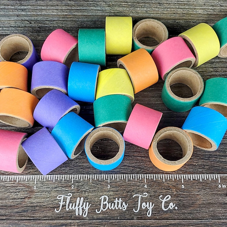 May include: A collection of colorful cardboard rings, each with a different color, including purple, blue, green, yellow, orange, and pink. The rings are stacked on top of each other and are arranged in a random pattern. The rings are made of cardboard and are about 2 inches in diameter. The rings are perfect for a variety of crafts and activities, such as making necklaces, bracelets, or keychains.