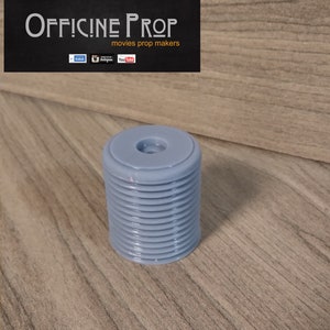 May include: A light blue plastic prop with a ribbed design and a small hole in the center. The prop is about 2 inches tall and 1 inch in diameter.