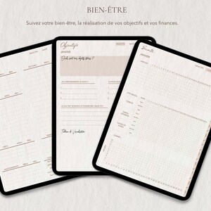 May include: Three digital tablets displaying planner pages. The tablets show a budget, goals, and health tracker. The text on the tablets is in French. The background is a light beige color.