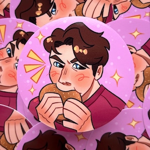 May include: A collection of round, pink buttons featuring a cartoon illustration of a person eating a burger. The person has brown hair, blue eyes, and a red shirt. The buttons have a sparkly design.