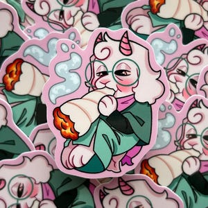 Puede incluir: Una pegatina con un personaje de dibujos animados de piel rosa, con gafas y un atuendo verde, sosteniendo un cigarrillo liado encendido. La pegatina tiene un fondo rosa con un diseño de nube y está rodeada de otras pegatinas similares.